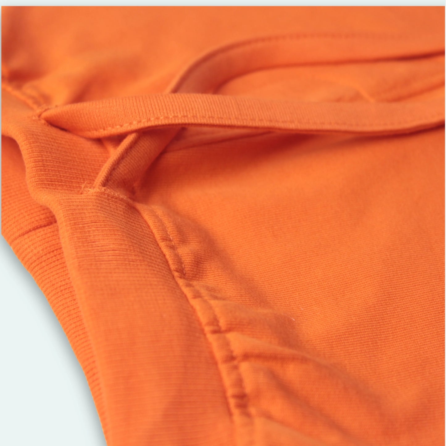 Elastic waistband detail of orange cotton shorts – soft stretch fit and easy to wear baby clothes for boys
