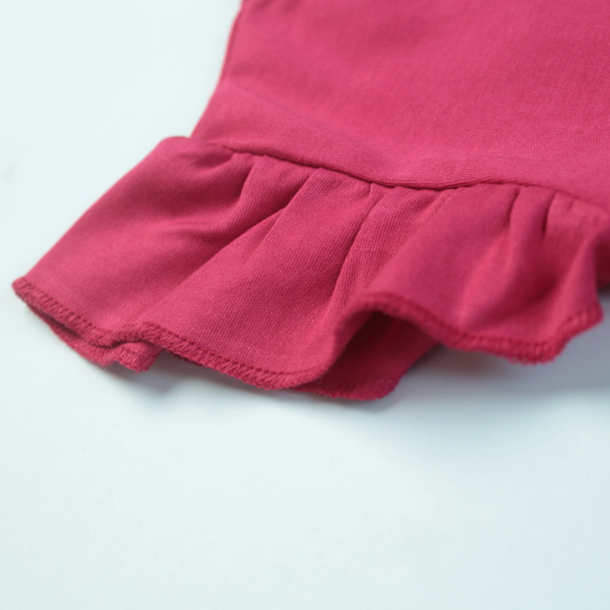 Close-up of adorable elephant placement print on dark pink cotton T-shirt – cute and playful baby clothes for girls.