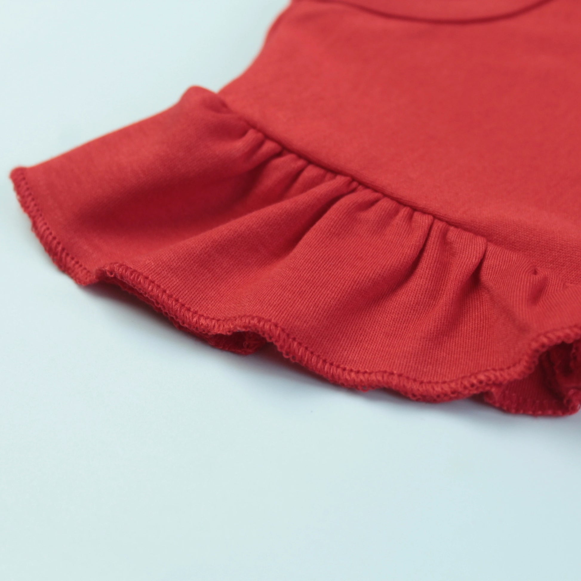 Detailed fabric and stitching view of red unicorn print T-shirt – high-quality and durable baby clothes for girls.