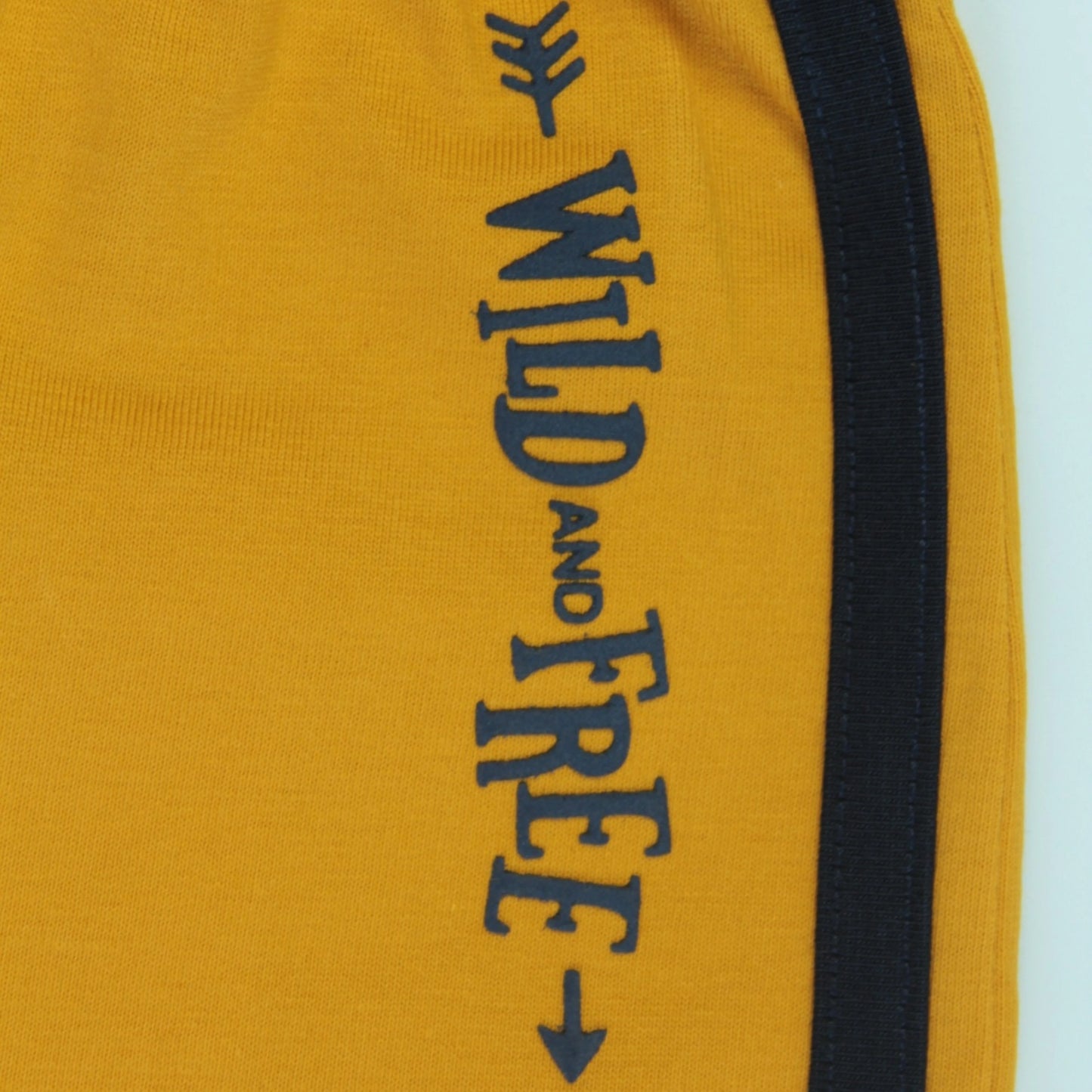 Lifestyle image of yellow boys' cotton shorts with tape detailing, a trendy and comfortable boys' clothing essential from Littleseeds™.