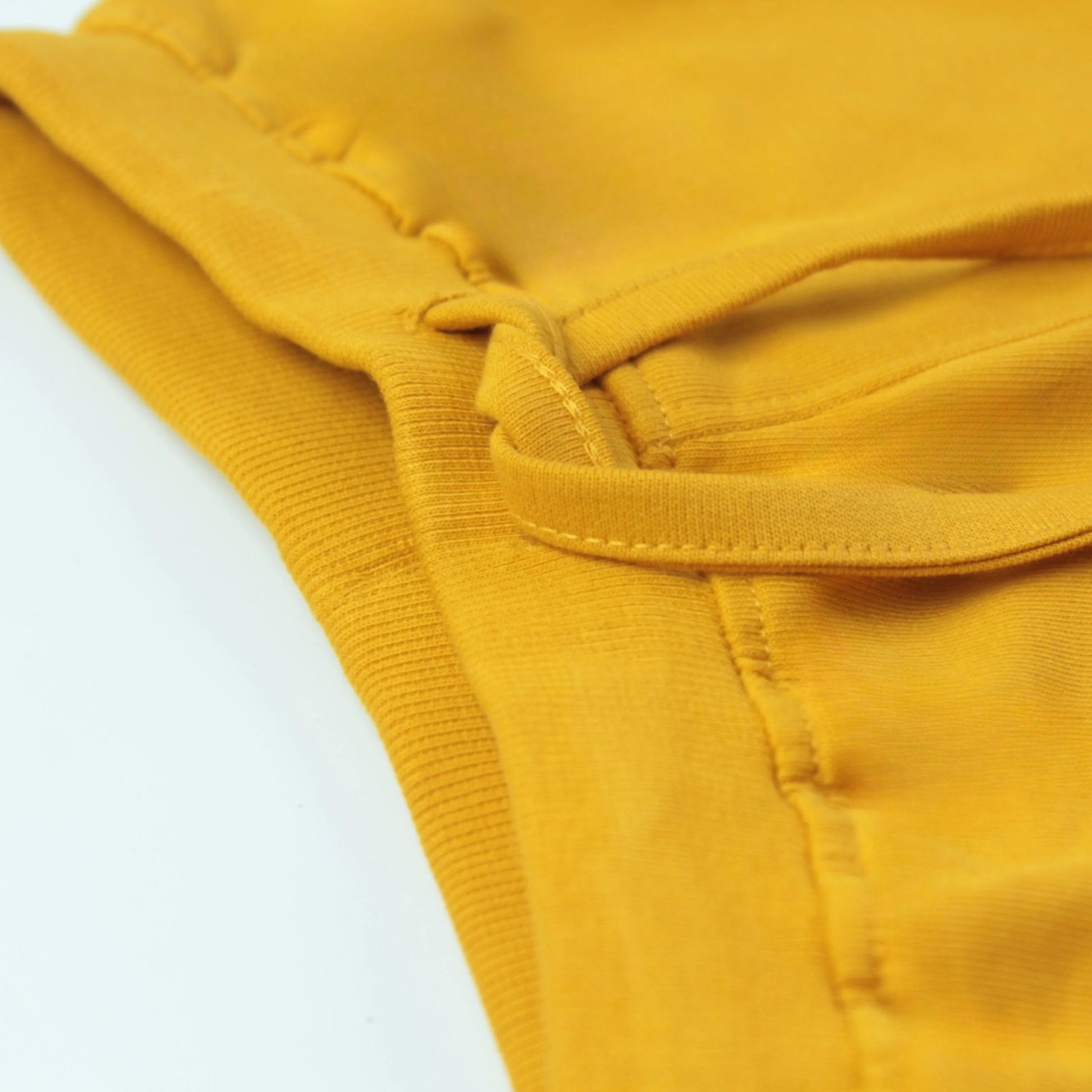 Close-up of golden infants shorts waistband – elastic design ensures comfortable fit and easy wear for babies and toddlers