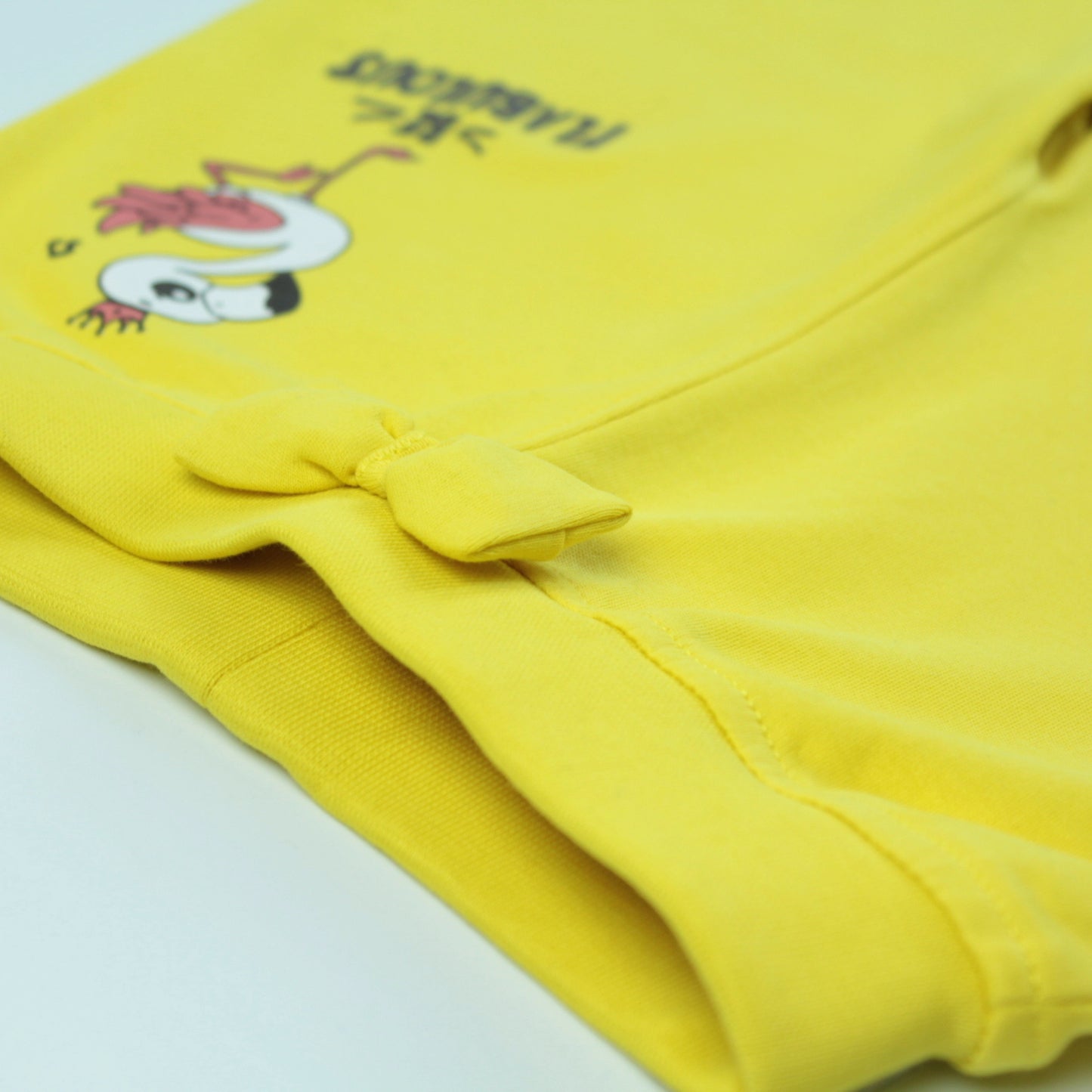 Detailed view of stitching and soft cotton fabric on yellow joggers – premium quality ladki dress for daily wear