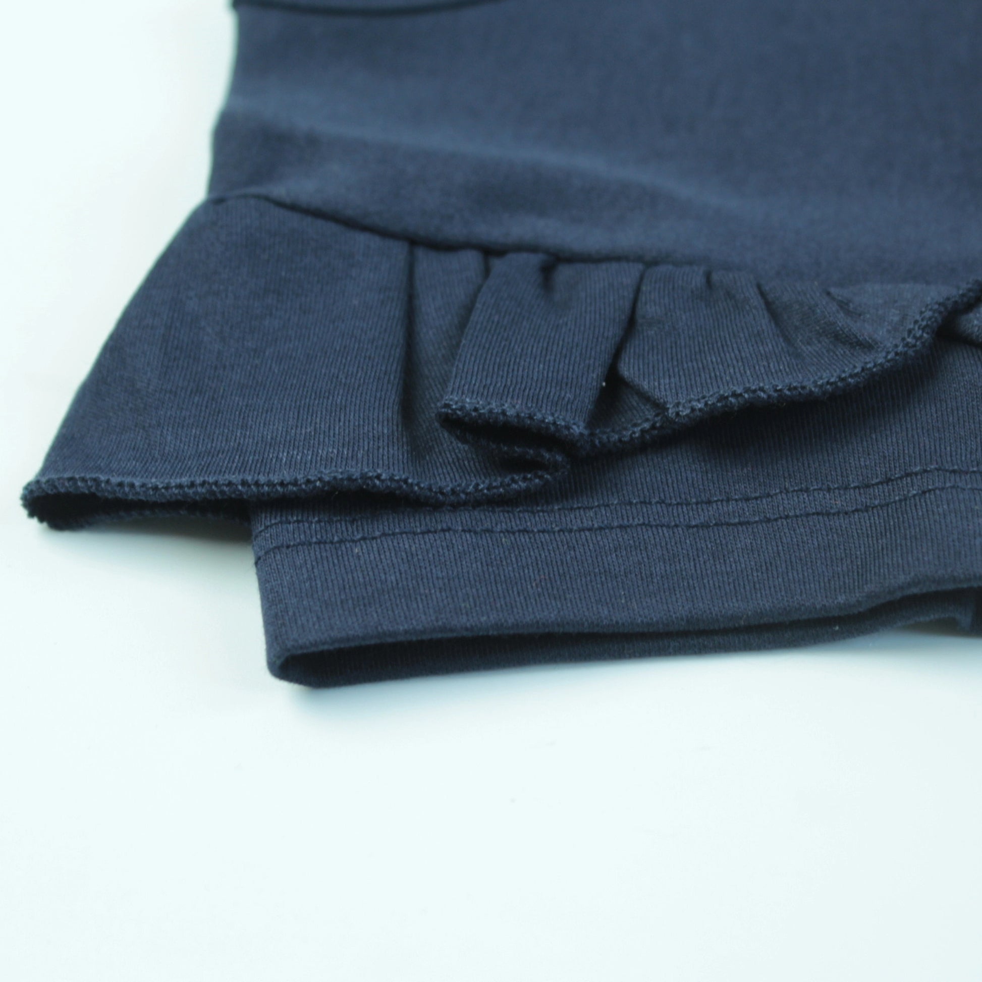 Close-up of floral print on navy cotton T-shirt – stylish and playful ladki dress for everyday use.