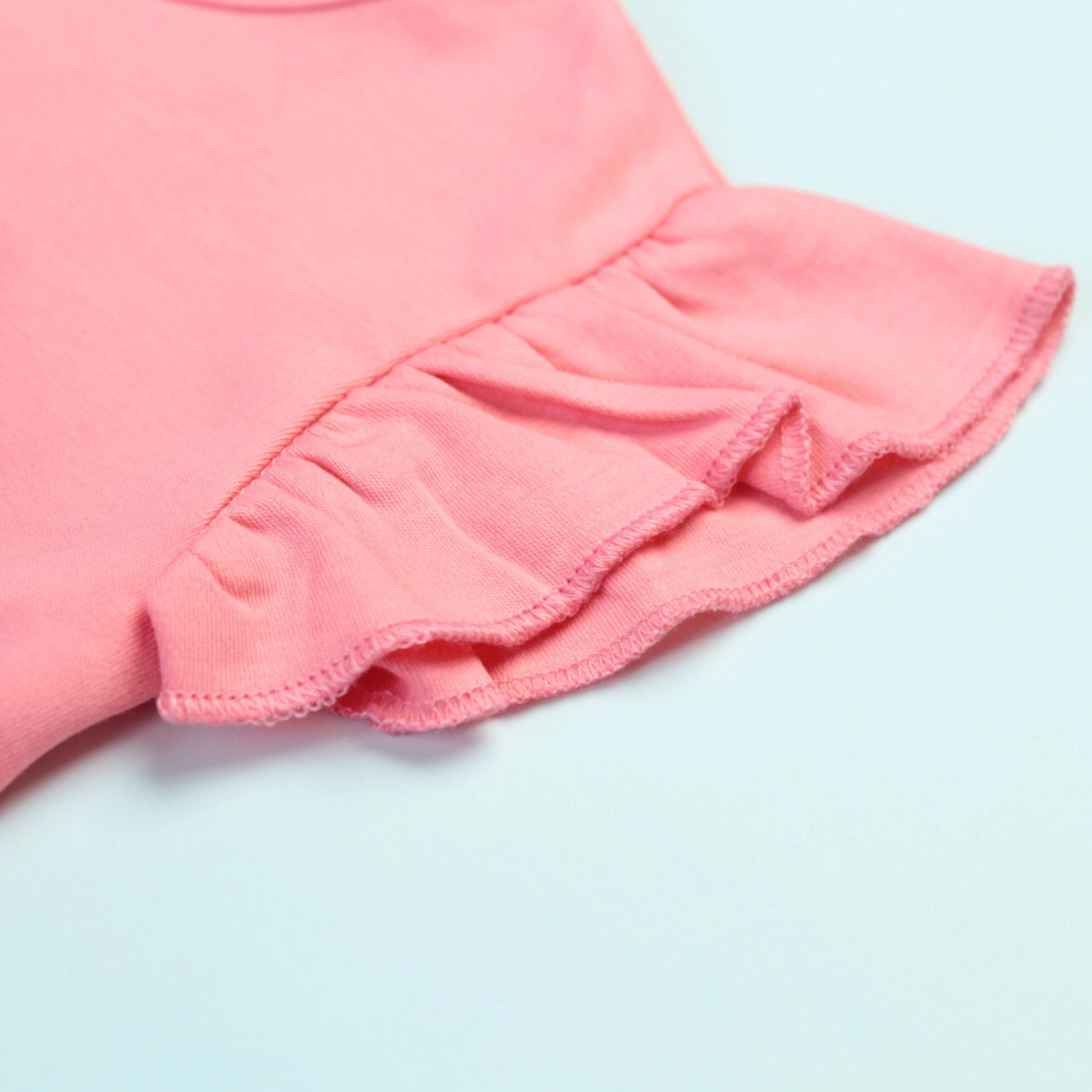 Detailed view of fabric and stitching on pink cotton cupcake T-shirt – soft and durable ladki dress for kids.