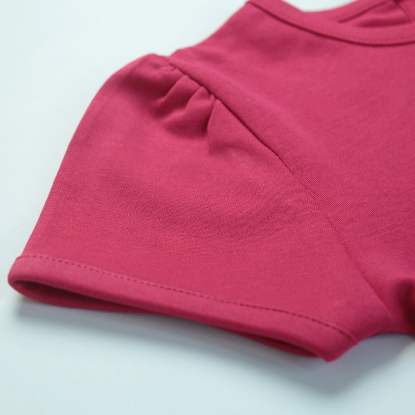 Detailed view of soft fabric and stitching on dark pink T-shirt – high-quality and comfortable night dress for childrens.