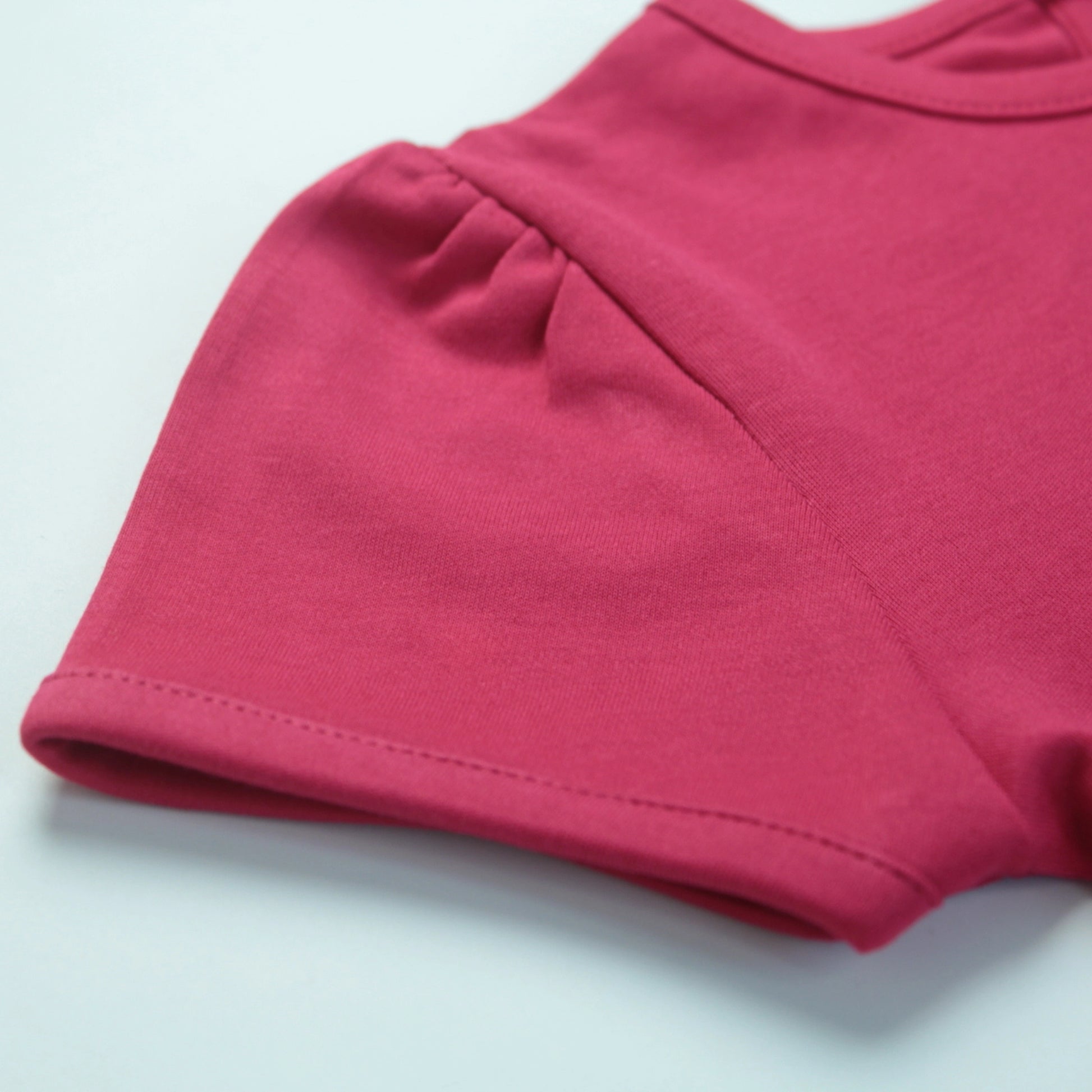Detailed view of soft fabric and stitching on dark pink T-shirt – high-quality and comfortable night dress for childrens.