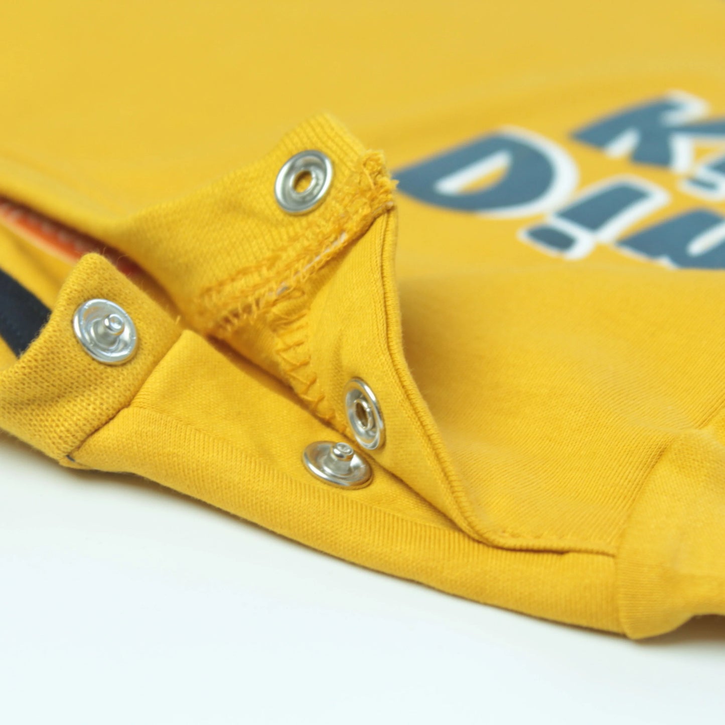 Close-up of boys yellow cotton t shirt with detailed dinosaur print – breathable fabric and premium finish