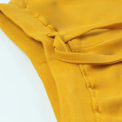 Close-up of golden cotton infants shorts with soft elastic waistband – designed for comfort and easy wear for active kids